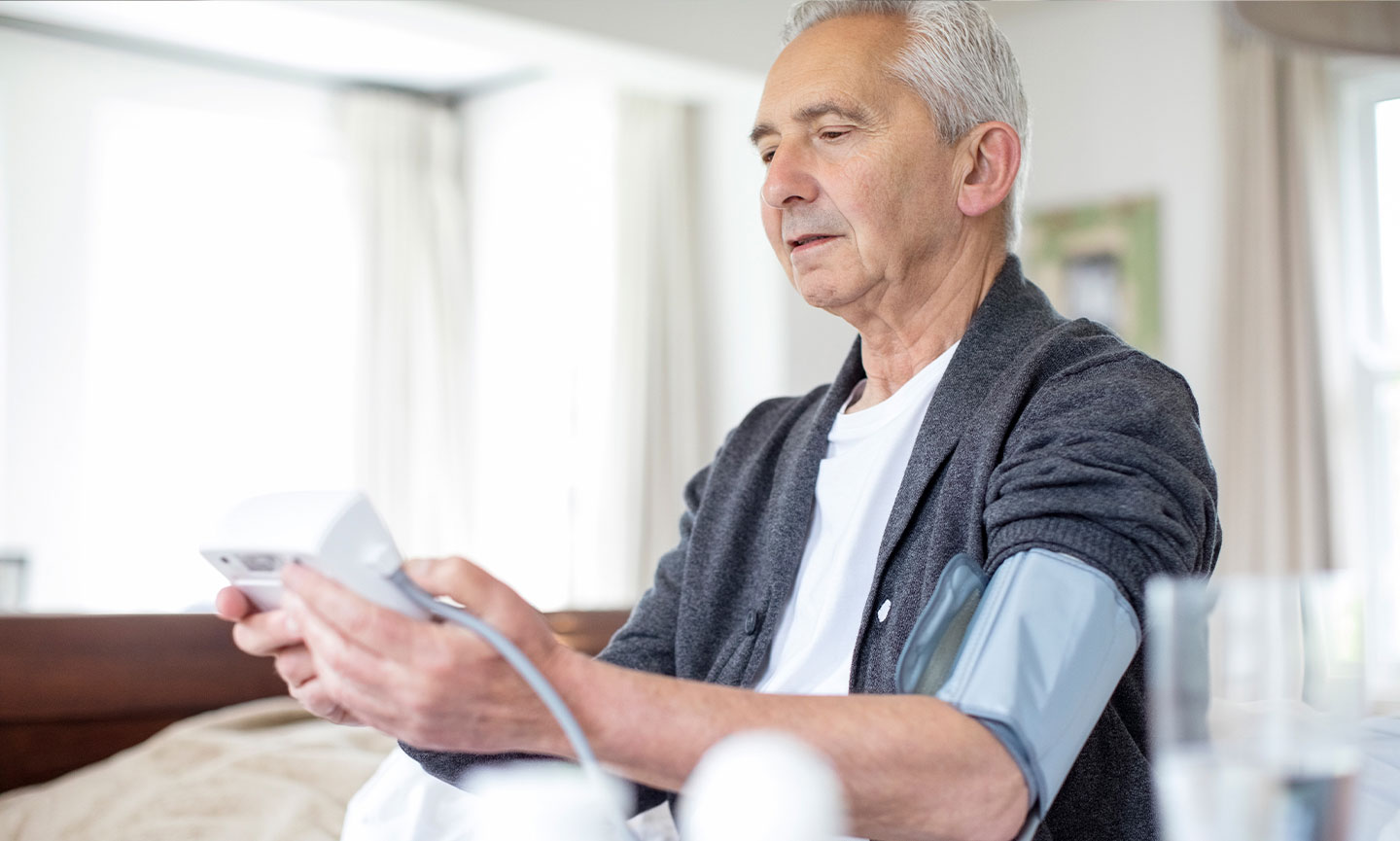 Older adult using a connected blood pressure monitor at home